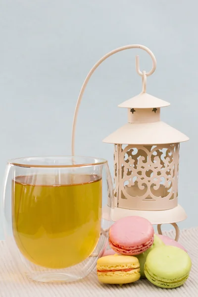 Macaroon, a cup of green tea and white metal candle holder — Stock Photo, Image