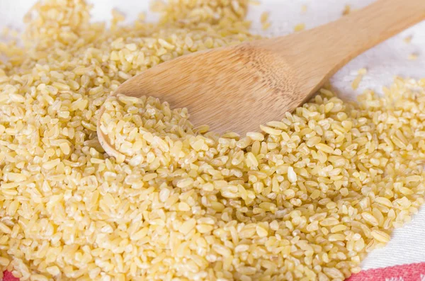 Bulgur in a wooden spoon — Stock Photo, Image