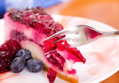 Parçası cheesecake taze çilek ile renkli bir tabak üzerinde