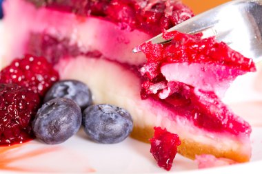 Parçası cheesecake taze çilek ile renkli bir tabak üzerinde