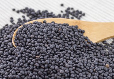 Tahta kaşık ile siyah, kırmızı ve sarı mercimek