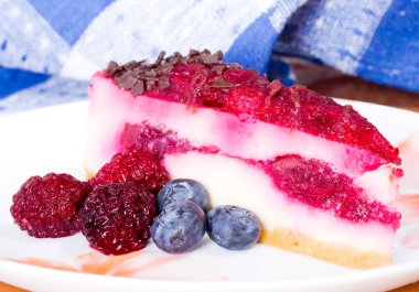 Parçası cheesecake taze çilek ile renkli bir tabak üzerinde