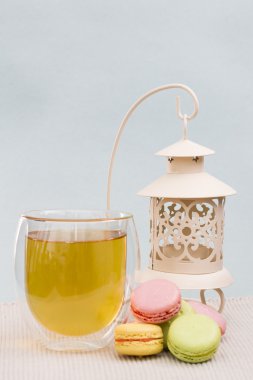 acıbadem kurabiyesi bir fincan yeşil çay ve beyaz metal Mumluk