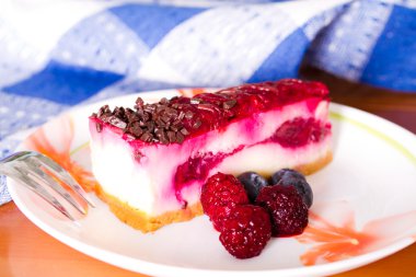 Parçası cheesecake taze çilek ile renkli bir tabak üzerinde