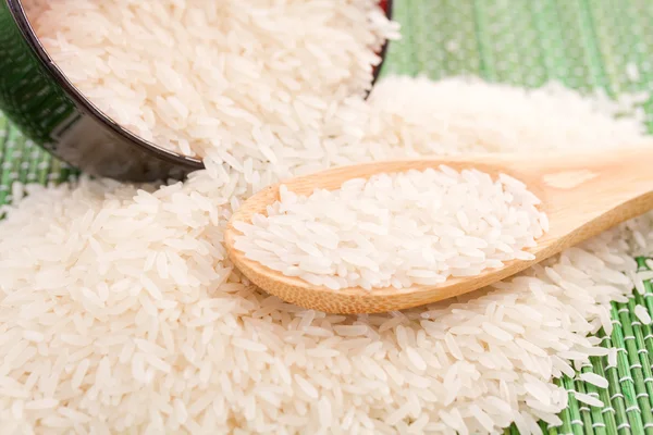 Plate with white rice and wooden spoon with white rice — Stock Photo, Image