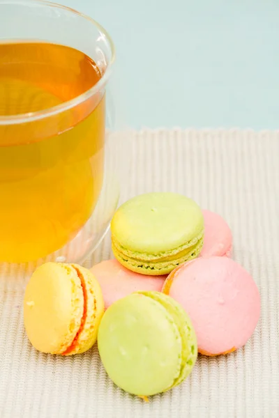 Delicate French cookies and glass cup of tea — Stock Photo, Image