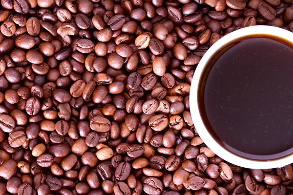 Taza de café sobre un fondo granos de café —  Fotos de Stock