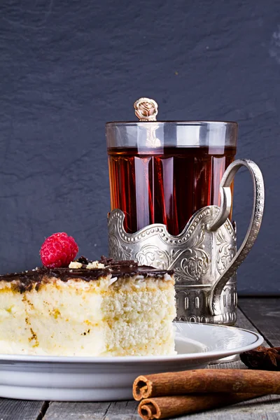Tort cu cremă de ciocolată și o ceașcă de ceai în suportul de ceașcă — Fotografie, imagine de stoc