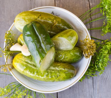 Tuzlu salatalık ve ahşap bir masa üzerine dereotu