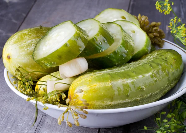 Pepino salgado e endro em uma mesa de madeira — Fotografia de Stock