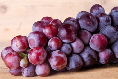 Hafif bir tahta üzerinde üzüm demet