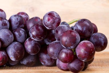 Hafif bir tahta üzerinde üzüm demet