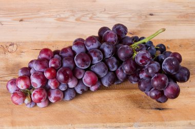 Hafif bir tahta üzerinde üzüm demet