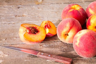 Olgun şeftali ve eski bir ahşap masa üzerinde bir bıçak