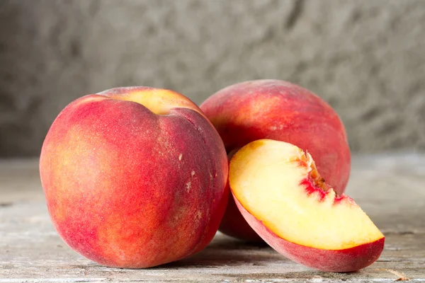 Ripe whole and sliced peaches — Stock Photo, Image