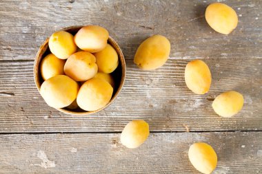 Eski ahşap masa üzerinde sulu olgun kayısı