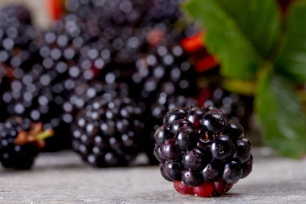Blackberries on the old wooden table in traditional Russian dish — Stock Photo, Image