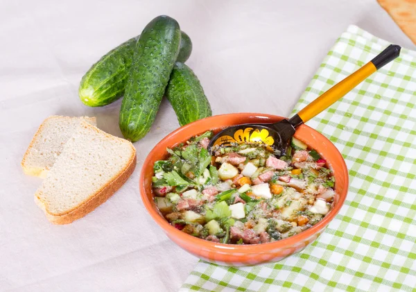 Okroshka em kvass em um boliche cerâmico em uma mesa e um spoo de madeira — Fotografia de Stock