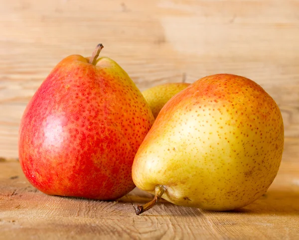 Ripe juicy pear on a wooden board — Stock Photo, Image