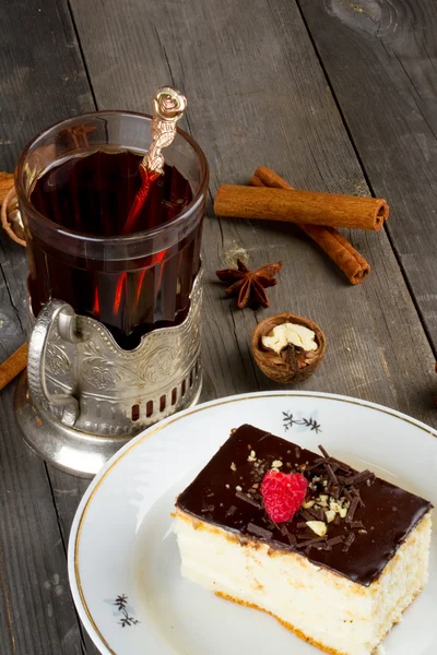Tort cu cremă de ciocolată și o ceașcă de ceai în suportul de ceașcă — Fotografie, imagine de stoc