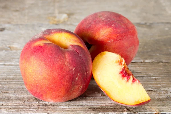 Ripe whole and sliced peaches — Stock Photo, Image