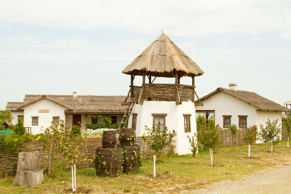 TAMAN, RUSSIA - AUGUST 12: Old wattle and daub hut and an observation tower Cossack in the ethnographic village Ataman on August 12, 2015 in Taman.