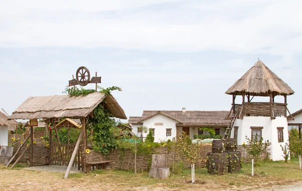TAMÁN, RUSIA - 12 DE AGOSTO: Antigua choza de lagartijas y daub y una torre de observación cosaca en la aldea etnográfica Ataman el 12 de agosto de 2015 en Taman . — Foto de Stock