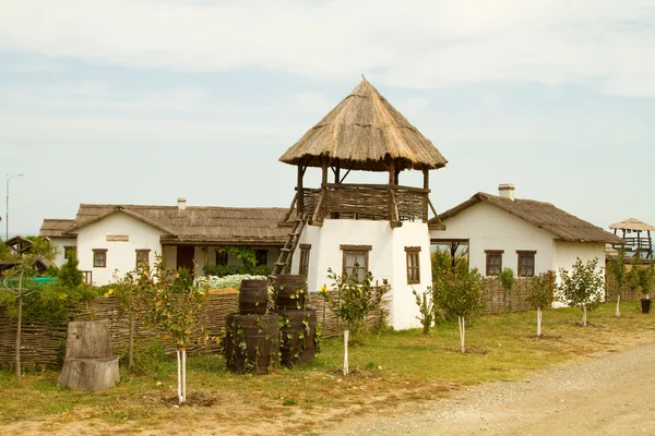 TAMANO, RÚSSIA - 12 DE AGOSTO: Velha cabana de wattle e daub e um observador — Fotografia de Stock