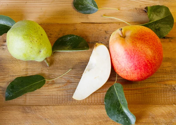 Whole and slice of ripe pears and green pear on a blackboard — Stock Photo, Image