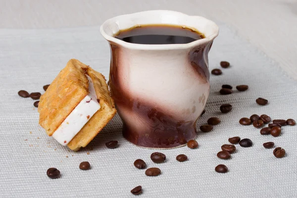 Taza de café, gofres y granos de café sobre la mesa —  Fotos de Stock