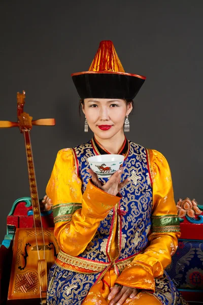 Cute Asian girl in Buryat costume drinking tea — Stock Photo, Image