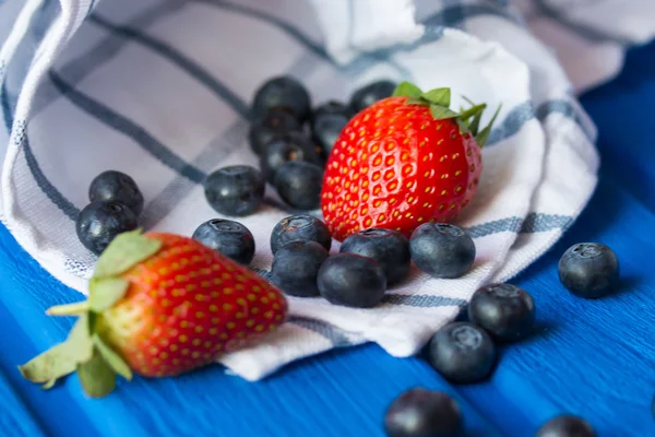 Blueberries and Victoria on a wooden surface — Stock Photo, Image