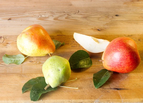 Whole and slice of ripe pears and green pear on a blackboard — Stock Photo, Image
