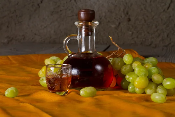 Decanter of brandy and grape — Stock Photo, Image