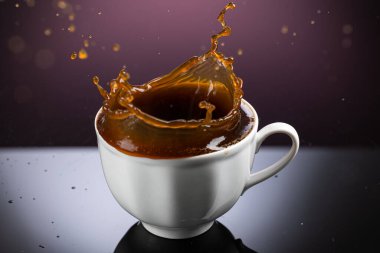 Beyaz fincanda kahve sıçraması. Arkaplanda yansıma var.