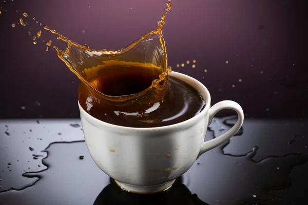 グラデーションを背景にした白いマグカップのコーヒースプラッシュ — ストック写真