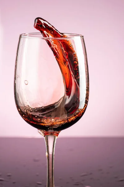 Stänk Rött Vin Glas Röd Bakgrund — Stockfoto