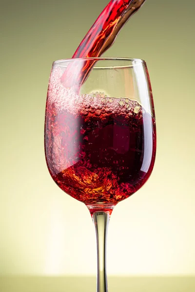 黄色の背景に赤ワインのスプラッシュ — ストック写真