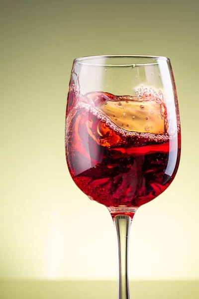Stänk Rött Vin Glas Gul Bakgrund — Stockfoto