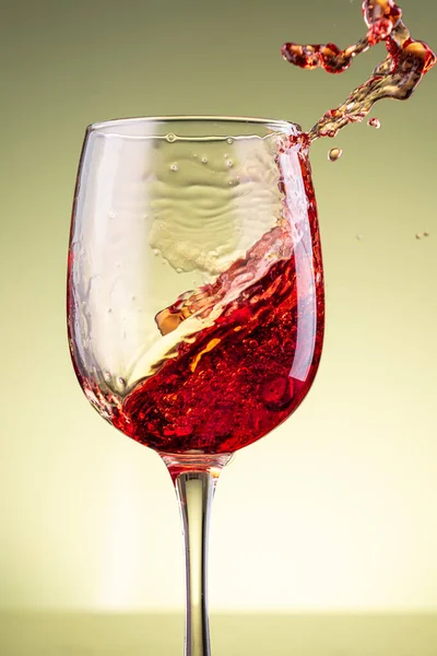 Stänk Rött Vin Glas Gul Bakgrund — Stockfoto