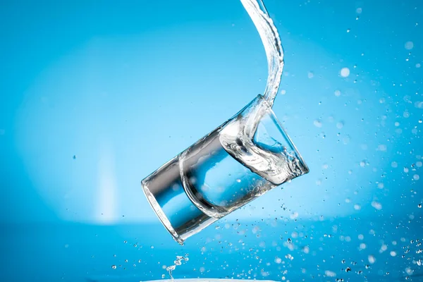 Respingo Cair Copos Com Água Fundo Azul — Fotografia de Stock
