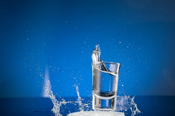 Salpicadura Vasos Que Caen Con Agua Sobre Fondo Azul — Foto de Stock