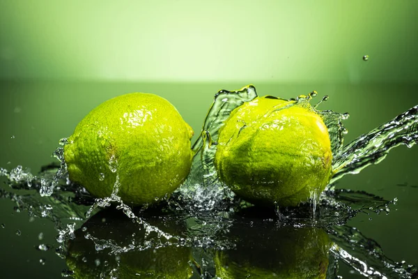 Two Green Limes Gradient Background Splash Water Drops Stock Photo