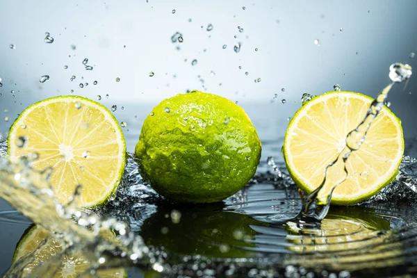 Two Green Limes Gradient Background Splash Water Drops Royalty Free Stock Photos
