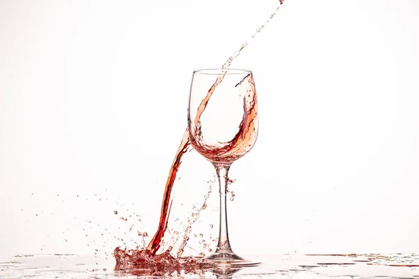 白い背景のガラスに赤ワインのスプラッシュと流れを映し出し — ストック写真