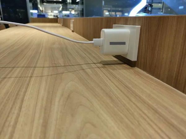 Ein Weißes Ladegerät Ist Den Strom Auf Dem Holztisch Angeschlossen — Stockfoto