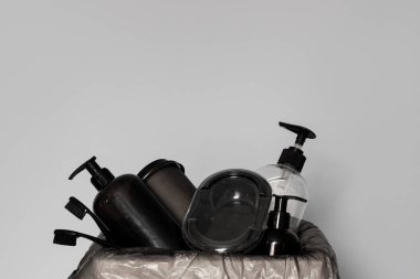 Geri dönüşüm, ekoloji ve minimalizm kavramına göre, gri arka planda siyah plastikten yapılmış çöplerin geri dönüşümü için çöp kutusu. Plastik atık. Doğa çöplüğü, ekoloji çevre koruma kavramı.