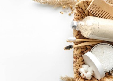 Vücut fırçası, kayın diş fırçası, deniz banyosu tuzu, iki çeşit sabun, ahşap saç tarağı ve arka plandaki diğer spa nesneleri. Üst manzara, düz yatış. Cilt bakımı, vücut tedavisi. Metin için boşluk.