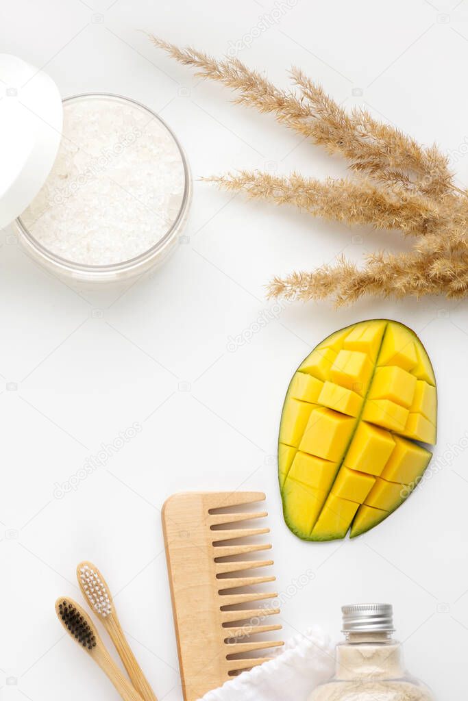 Spa treatment concept, flat lay composition with natural cosmetic products, top view, blank space for a text. Body scrub, soap, string eco bag, beech toothbrushes, sea bath salt, body brush, mangos