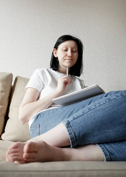 Een Meisje Jeans Een Wit Shirt Zit Een Bank Denkt — Stockfoto